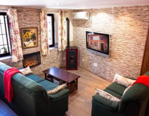 a living room with two couches and a brick wall at Casa Rural Los Enebros in Los Navalucillos