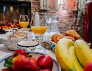 a breakfast table with fruit and glasses of orange juice at Casa Rural Los Enebros in Los Navalucillos