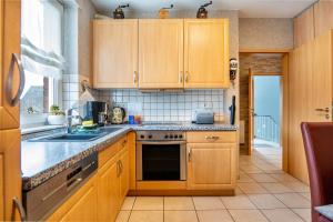 a kitchen with wooden cabinets and a sink at Münsterland Stadtlohn in Stadtlohn