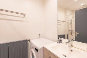 a bathroom with a sink and a washing machine at Studio cosy & design in Bagnères-de-Bigorre +11 photos