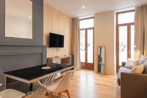 a living room with a table and a couch at Studio cosy & design in Bagnères-de-Bigorre