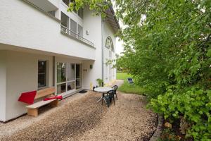 a patio with a table and chairs next to a building at Stumpp´s Appartement in Heroldstatt
