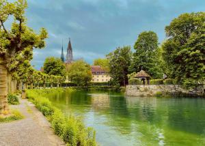 a river in a city with a church in the background at Inselgasse in Konstanz