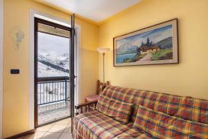 a living room with a couch and a window at Plain Soleil ski home in Prato Nevoso