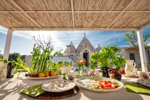 a table with plates of food and a church in the background at Trullo Nostress with pool in Ceglie Messapica