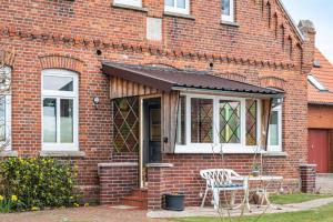 a brick house with a table and a chair at Ferienwohnung Dierking in Gilten