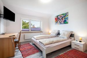 a bedroom with a bed and a desk and a computer at Ferienwohnung Dierking in Gilten