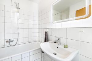 a white bathroom with a sink and a bath tub at Key2Komfort in Duisburg