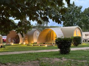 a row of tents in the grass with lights at Camping Arquebuse in Auxonne