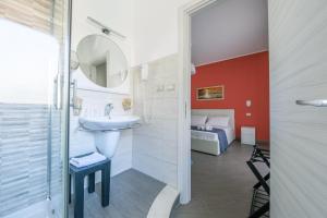 a bathroom with a sink and a mirror and a bed at Paladino in Giardini Naxos +59 photos
