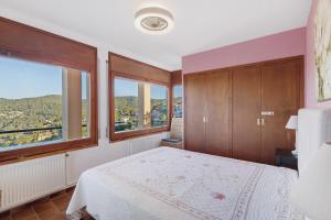 a bedroom with a bed and a large window at Racó 72 in Begur +31 photos