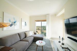 a living room with a couch and a large window at Penthouse Monte da Eira - Sunset in Albufeira