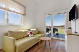 a living room with a couch and a balcony at Gästehaus Heimelig in Herbolzheim