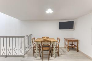 a dining room with a table and chairs and a tv at Casa Don Paolo in Alessano