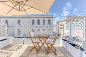 a table and chairs on a balcony with an umbrella at Casa Don Paolo in Alessano