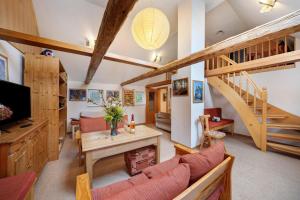 a living room with wooden ceilings and a staircase at Grünes Ferienhaus in Nassau