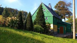a green building with trees in front of it at Grünes Ferienhaus in Nassau