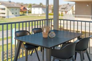 a black table and chairs on a balcony at Gästehaus Heimelig in Herbolzheim