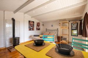 a living room with a yellow table and a bedroom at Cabaña Shadú in Lanjarón
