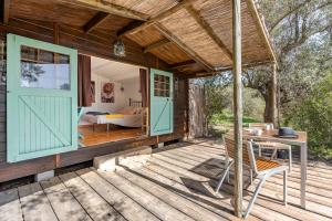 a wooden house with a door and a table on a deck at Cabaña Shadú in Lanjarón
