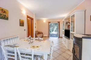 a kitchen and dining room with a white table and chairs at Casa Paola e del Poeta in Costa Carnara