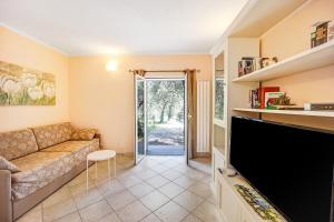 a living room with a couch and a flat screen tv at Casa Paola e del Poeta in Costa Carnara
