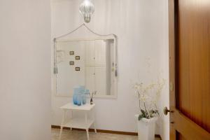 a hallway with a mirror and a table with vases at Zaffiro Apartment With Garage in Rapallo +30 photos