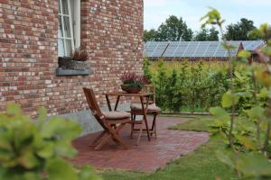 un patio con mesa y sillas y un edificio de ladrillo en Ferienwohnung Zur Remise, en Stadtlohn