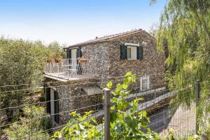 a stone house with a balcony and a fence at Casa Paola e del Poeta in Costa Carnara