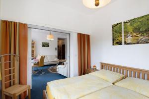 a hotel room with a bed and a living room at Der Falkenhorst in Bad Sachsa