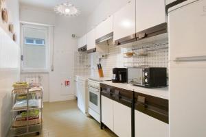 a kitchen with white cabinets and a microwave at Zaffiro Apartment With Garage in Rapallo