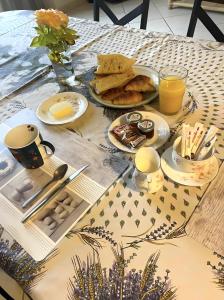 a table topped with plates of food and orange juice at Chambres d' hotes Terre Happy in Ribérac
