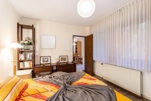 a bedroom with a bed and a desk and a window at Ferienwohnung am Mozarthügel in Warstein