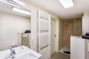 a white bathroom with a sink and a shower at Ferienwohnung am Mozarthügel in Warstein +15 photos