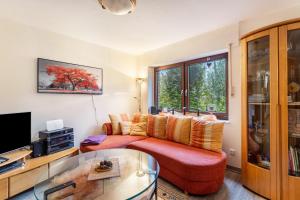 a living room with a red couch and a tv at Ferienwohnung am Mozarthügel in Warstein