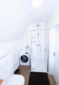 a bathroom with a shower and a washing machine at Ferienhaus 88 in Bad Arolsen +12 photos
