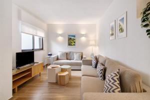 a living room with a couch and a tv at Pear Tree Villa in Vale do Lobo