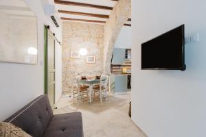 a living room with a tv and a table at Casa Mauro e Roberta Zingaro in Castellammare del Golfo