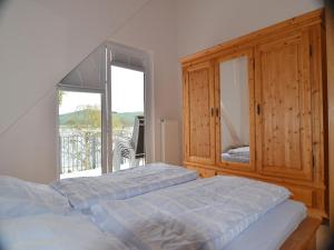 a bedroom with a bed and a large window at Ferienwohnung Ledergerber in Bodman-Ludwigshafen