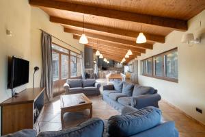 a living room with blue couches and a tv at Torigues in Santa María de Oló