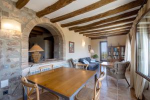 a kitchen and living room with a wooden table and chairs at Torigues in Santa María de Oló