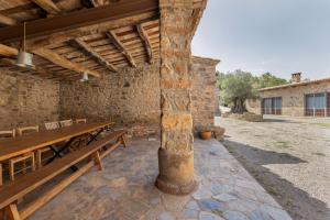 a stone building with a wooden table and benches at Torigues in Santa María de Oló