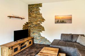 a living room with a couch and a stone wall at Seehund in Stedesdorf