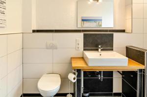 a bathroom with a sink and a toilet at Seehund in Stedesdorf +32 photos