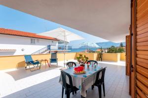 a patio with a table with chairs and an umbrella at Casa Viola - a 100 metri dal mare in Trappeto