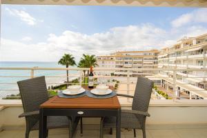 a table on a balcony with a view of the ocean at Costabella Altea in Altea +3 photos