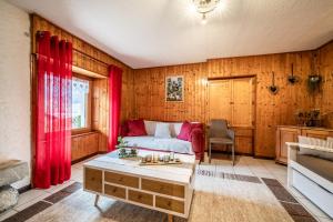 a living room with red curtains and a couch at Chez les Charles in Bernex