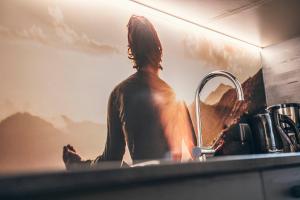a man sitting in a sink next to a picture at Lichtung Woldererhof Auszeit in Racines