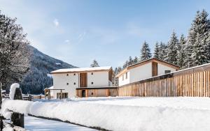 a house in the snow with a fence at Lichtung Woldererhof Auszeit in Racines