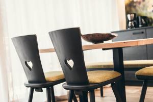 a table with two black chairs and a bowl on it at Lichtung Woldererhof Auszeit in Racines +13 photos
